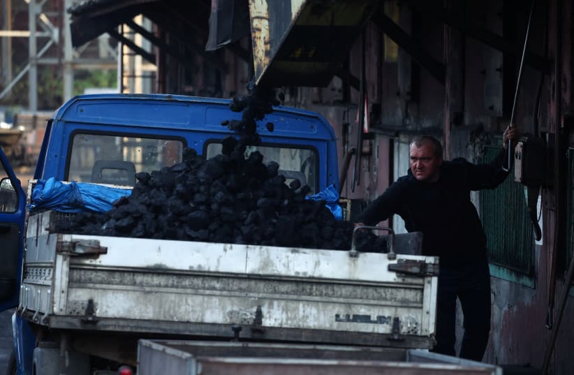  A man loads coal onto a truck at the Bobrek mine, in Bytom, Poland October 27, 2022. (photo credit: REUTERS/KACPER PEMPEL)