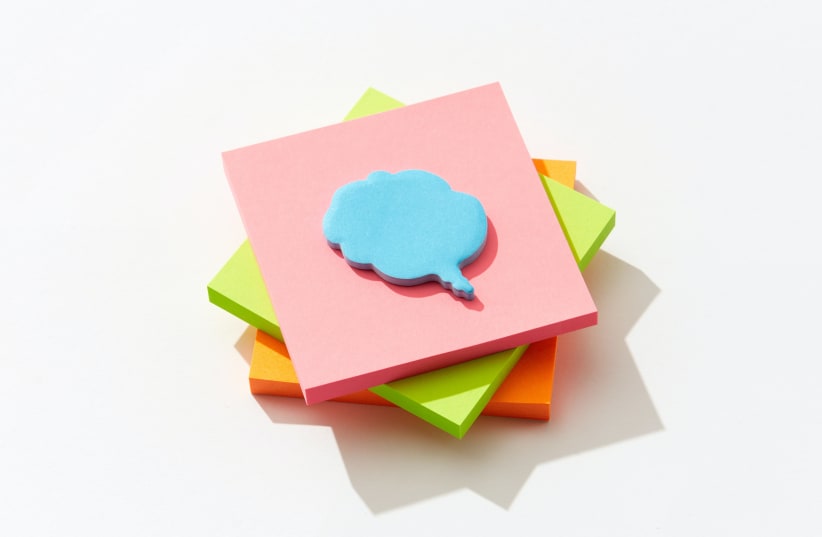 A speech bubble on a stack of notes. (Illustrative) (photo credit: DS stories/Pexels)