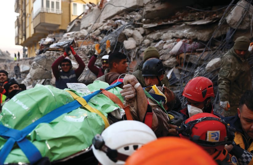  RESCUERS FROM Turkey and United Hatzalah carry a survivor in the aftermath of a deadly earthquake, in Kahramanmaras, Turkey, this February.  (photo credit: RONEN ZVULUN/REUTERS)