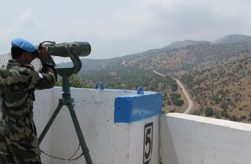  A UN peacekeeper uses binoculars to monitor the Shebaa Farms area, wedged between Lebanon and the Golan Heights August 23, 2008.  (photo credit: Alistair Lyon/Reuters)