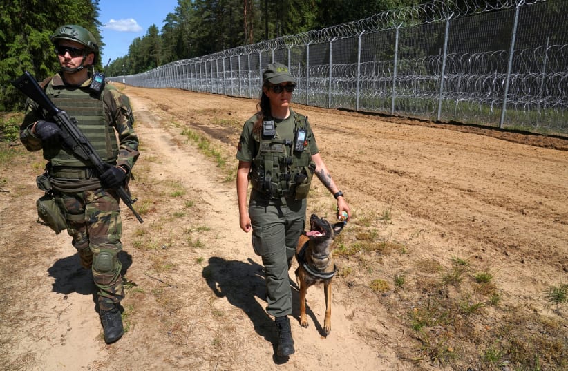 A member of Lithuanian Riflemen's Union and a Border Guard officer patrol along Belarus border in Kaniukai, Lithuania July 7, 2023. (photo credit: REUTERS/JANIS LAIZANS)