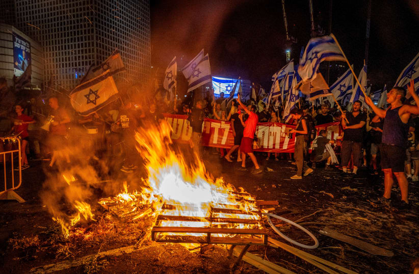 Israelis block the Ayalon Highway during a protest against the Israeli government's planned judicial overhaul and in response to the removal of Tel Aviv District commander Ami Eshed in Tel Aviv, July 5, 2023.  (photo credit: YOSSI ALONI/FLASH90)