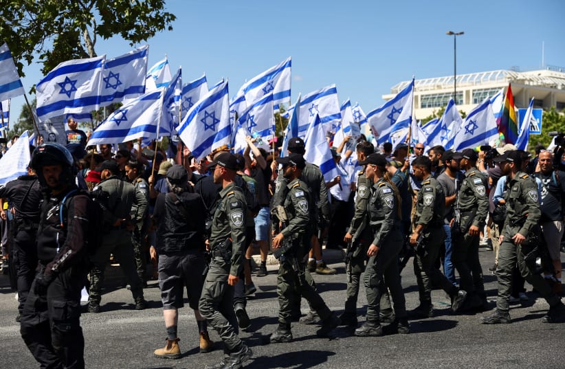  Members of the security forces stand guard as people demonstrate on 'Day of Disruption' in protest against Israeli Prime Minister Benjamin Netanyahu and his nationalist coalition government's judicial overhaul, outside the Supreme Court in Jerusalem, July 11, 2023. (photo credit: RONEN ZVULUN/REUTERS)