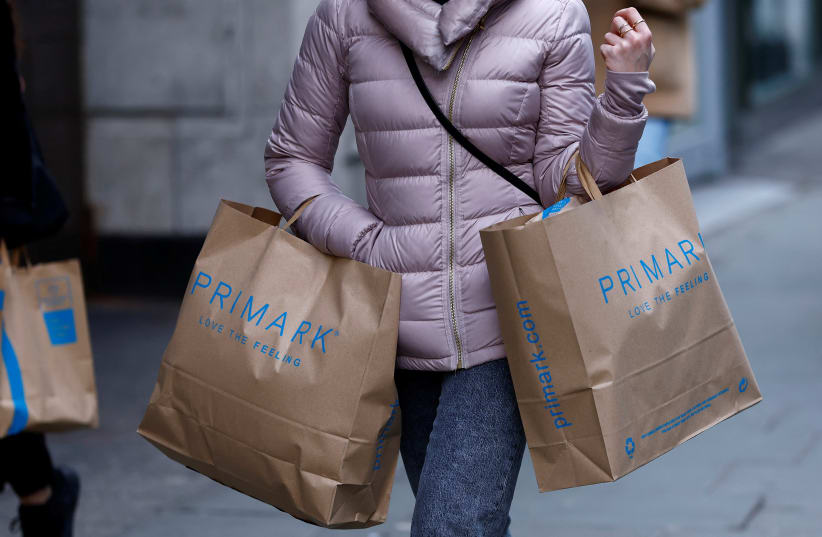  A woman carries Primark shopping bags on Oxford Street, in London, Britain, January 16, 2023.  (photo credit: REUTERS/PETER NICHOLLS)