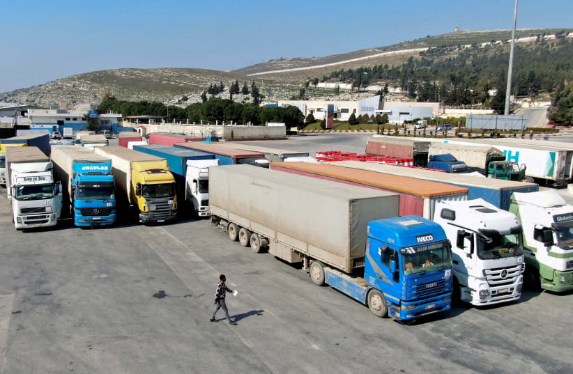 Trucks carrying aid from the UN World Food Programme (WFP), following a deadly earthquake, are parked at Bab al-Hawa crossing, Syria, February 20, 2023 (photo credit: REUTERS/MAHMOUD HASSANO)