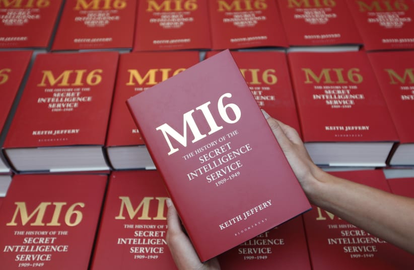  A woman holds a copy of The History of the Secret Intelligence Service for photographs at its launch at the Foreign Office in central London, September 21, 2010.  (photo credit: ANDREW WINNING/REUTERS)