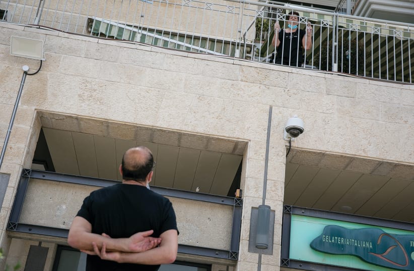  A MAN speaks with his mother, who lives in a retirement home in Jerusalem, during COVID restrictions in 2020 (photo credit: OLIVIER FITOUSSI/FLASH90)