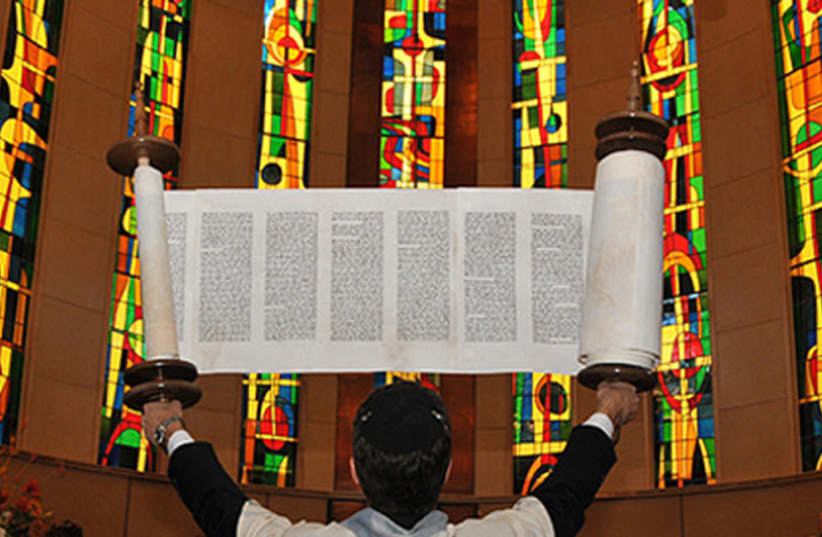  A Torah held aloft at a reconstructionist synagogue. (photo credit: Wikimedia Commons)
