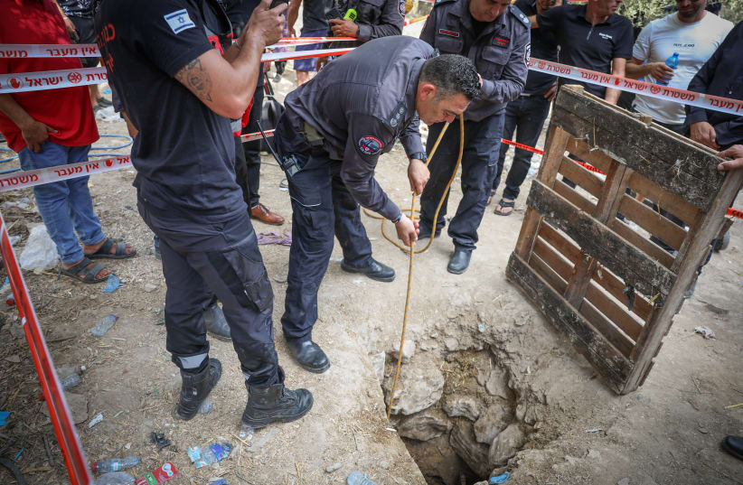  Police and rescue personnel at the scene where three people were injured when they fell into an 8-m deep pit  in the ground in Deir el-Asad, Northern Israel on August 13, 2023 (photo credit: David Cohen/Flash90)