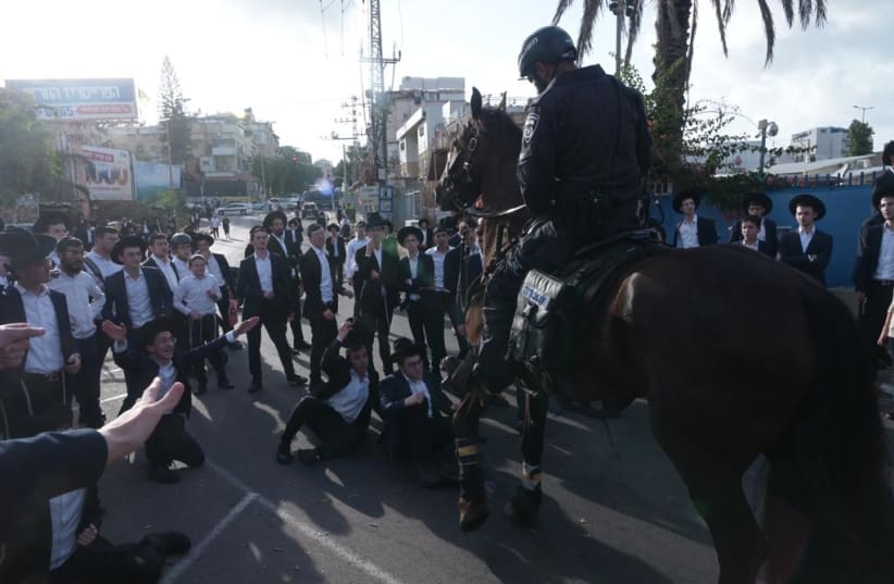  Haredi protesters are seen standing off with an Israel Police officer and horse, on September 13, 2023. (photo credit: AVSHALOM SASSONI/MAARIV)