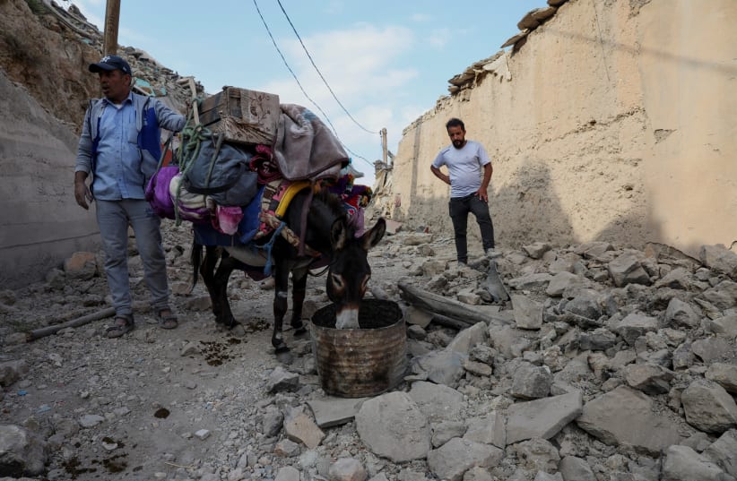  A man stands next to a donkey that carries his belongings days after the deadly earthquake, in the village of Adouz, Morocco September 12, 2023. (photo credit: REUTERS/EMILIE MADI)