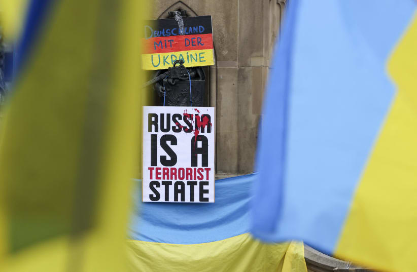  A sticker that reads "Russia is a terrorist state" is attached to a flag of Ukraine during a gathering to protest against a pro-Russia demonstration amid the Russian invasion of Ukraine in Frankfurt, Germany, September 18, 2022 (photo credit: REUTERS)