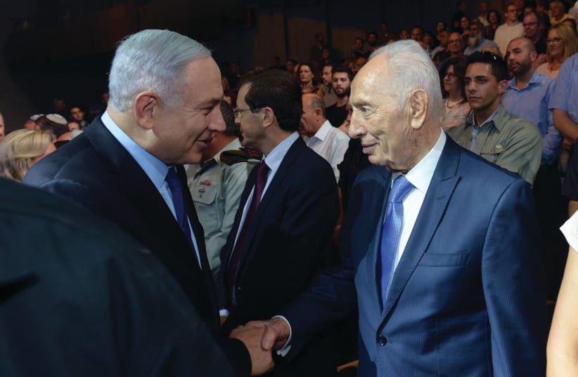  PRIME MINISTER Benjamin Netanyahu shakes hands with former president and prime minister Shimon Peres at a state ceremony in 2016, marking the 40th anniversary of Operation Entebbe. (photo credit: HAIM ZACH/GPO)