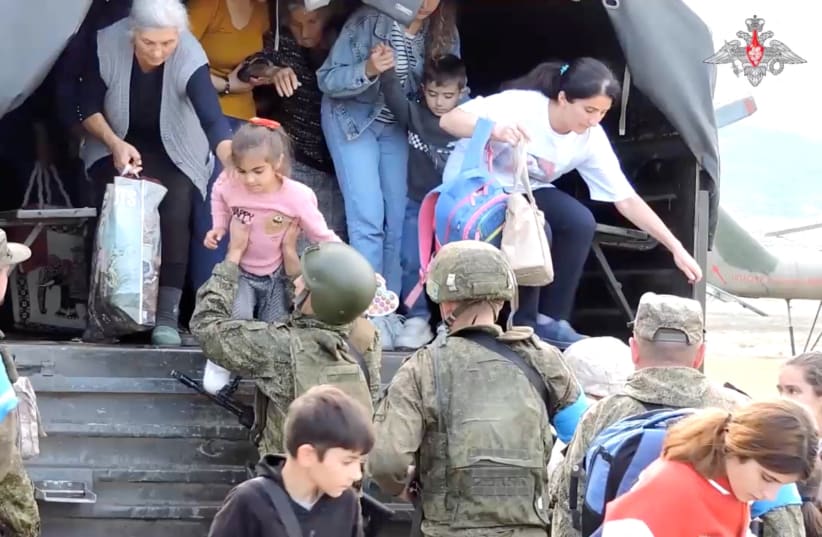  Civilians get out of a truck during an evacuation performed by Russian peacekeepers at an unknown location following the launch of a military operation by Azerbaijani forces in Nagorno-Karabakh, a region inhabited by ethnic Armenians, in this still image from video published September 20, 2023. (photo credit: RUSSIAN DEFENSE MINISTRY/HANDOUT VIA REUTERS)
