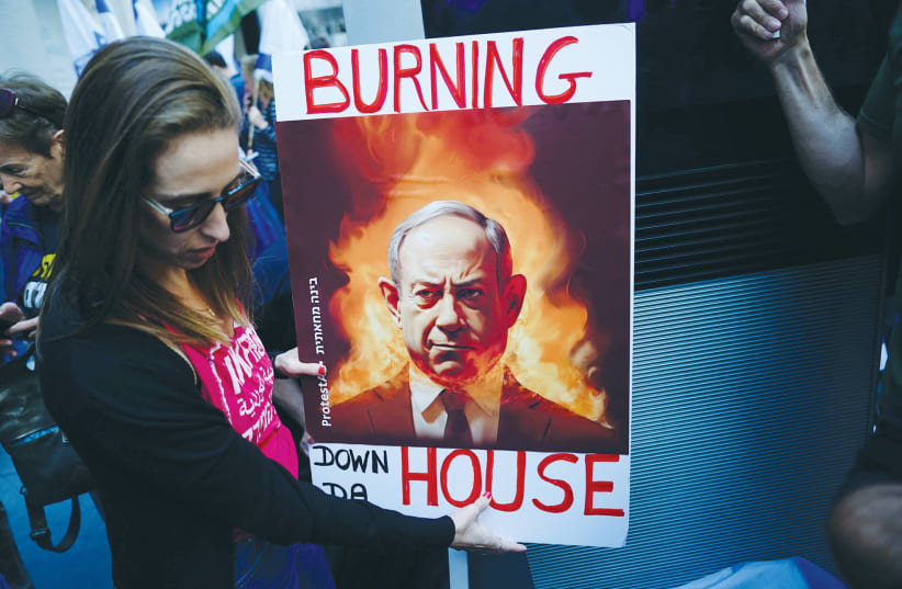  A WOMAN holds an AI-generated image of Prime Minister Benjamin Netanyahu as Israelis and Israeli Americans protested near the hotel in New York where he and US President Joe Biden were meeting, on Wednesday.  (photo credit: BING GUAN/REUTERS)