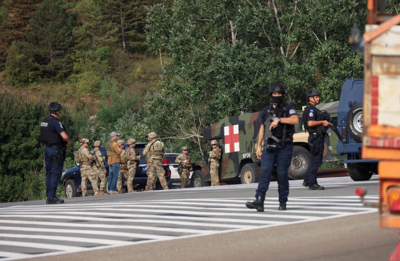  People work as Kosovo police and US and EU troops stand by after one police officer was killed, another hurt in Kosovo gunfire, in Josevik, Kosovo September 24, 2023. (photo credit: REUTERS/FATOS BYTYCI)