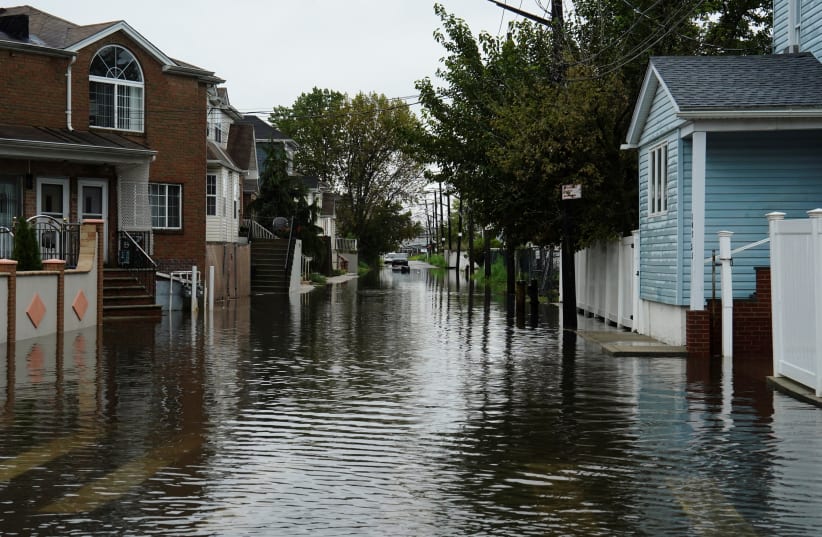 Floodwaters fill the residential street of Rau Court, as the remnants of Tropical Storm Ophelia bring flooding across the mid-Atlantic and Northeast, in the Hamilton Beach neighborhood in the Queens borough of New York City, U.S., September 29, 2023.  (photo credit: BING GUAN/REUTERS)