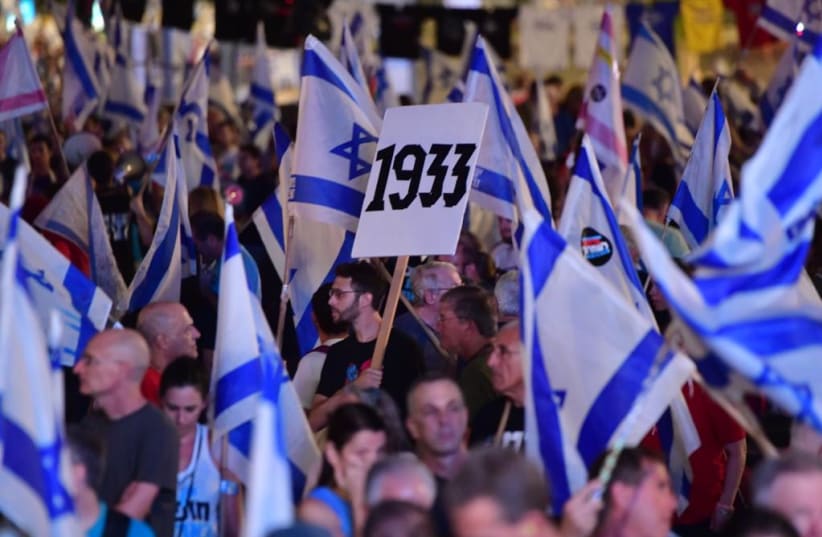 An anti-judicial reform protestor holding a sign reading "1933", the year Hitler came to power, September 30, 2023. (photo credit: AVSHALOM SASSONI)