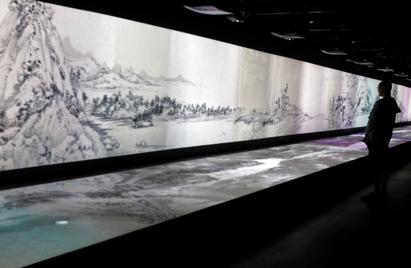  A visitor looks at an audio/visual interpretation of a painting entitled 'Dwelling in the Fuchun Mountains' by Chinese painter Huang Gongwang at the National Palace Museum in Taipei, June 1, 2011. (photo credit: REUTERS/Pichi Chuang/File Photo)