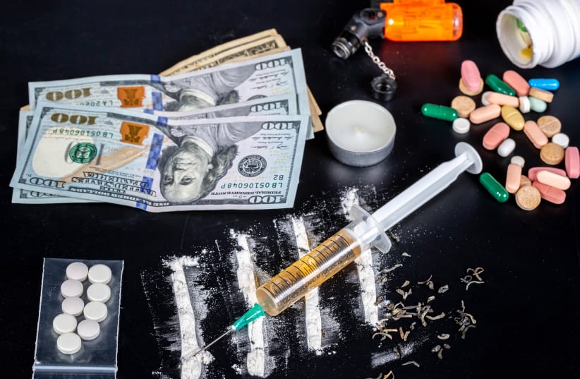  Money and various drugs on a black table. (photo credit: FLICKR)