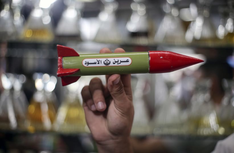 A Palestinian man sells perfume in packages shaped like homemade rocket models at his store in Gaza City, on October 2, 202 October 2, 2023 (photo credit: Yousef Mohammed/Flash90)
