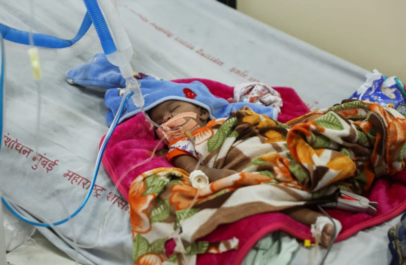  A child diagnosed with pneumonia is seen inside the pediatric ward of the Shankarrao Chavan Government Medical College and Hospital in Nanded, India, October 3, 2023 (photo credit: REUTERS/FRANCIS MASCARENHAS)