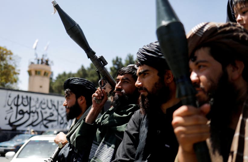  Taliban soldiers celebrate on the second anniversary of the fall of Kabul on a street near the US embassy in Kabul, Afghanistan, August 15, 2023 (photo credit:  REUTERS/ALI KHARA)