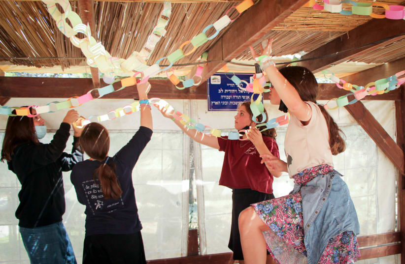  SUKKOT DECORATIONS, much as we love them, eventually need to be packed up (photo credit: GERSHON ELINSON/FLASH90)