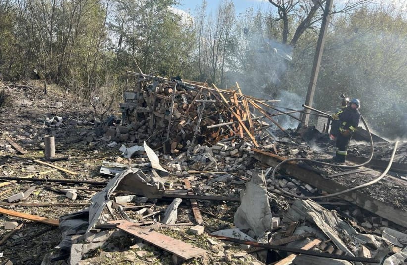 Firefighters work at a site of a Russian military strike, amid Russia's attack on Ukraine, in the village of Hroza, in Kharkiv region, Ukraine October 5, 2023. (photo credit: Head of Ukraine's Presidential Office Andriy Yermak via Telegram/Handout via REUTERS)