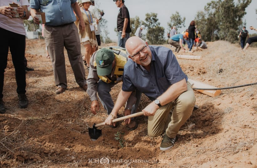  ICEJ President Dr Juergen Buehler plants a native oak tree in the new Christian Embassy Nature Park in the Be’eri Forest. (photo credit: ICEJ)