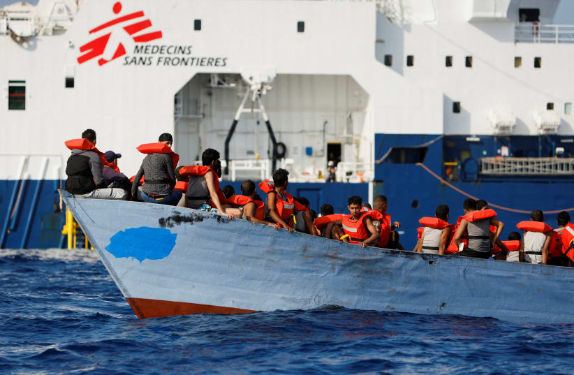  A group of 61 migrants on a wooden boat are rescued by crew members of the Geo Barents migrant rescue ship, operated by Medecins Sans Frontieres (Doctors Without Borders), in international waters off the coast of Libya in the central Mediterranean Sea September 28, 2023. (photo credit: REUTERS/DARRIN ZAMMIT LUPI)
