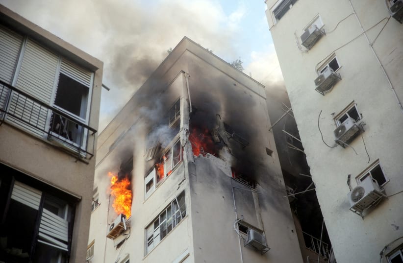  A building is ablaze following rocket attacks from the Gaza Strip, in Tel Aviv, Israel October 7, 2023.  (photo credit: REUTERS/ITAI RON)