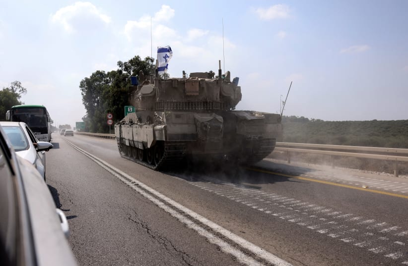  An Israeli tank drives on a road following a mass infiltration by Hamas terrorists from the Gaza Strip, near Sderot in southern Israel October 8, 2023 (photo credit: RONEN ZVULUN/REUTERS)