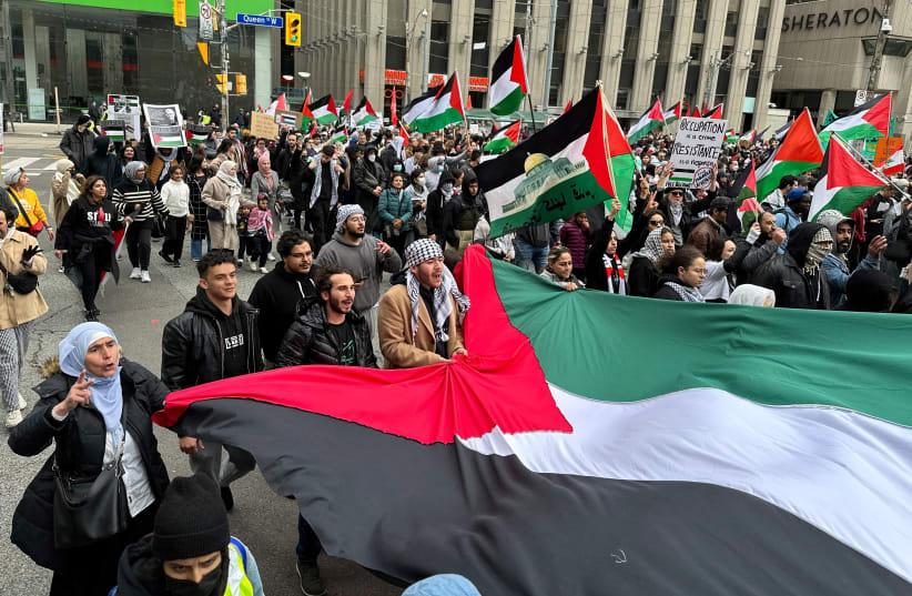  People carry a Palestinian flag during a rally in front of City Hall in Toronto, Ontario, Canada October 9, 2023. (photo credit: REUTERS/Kyaw Soe Oo)
