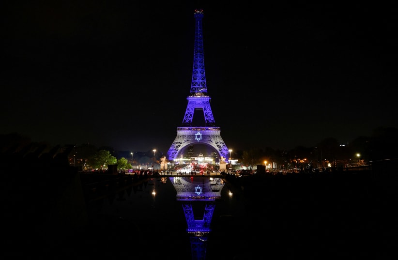  The Eiffel Tower lights up in white and blue, the colours of the Israeli flag, following Hamas' biggest attack on Israel in years, in Paris, France, October 9, 2023 (photo credit: REUTERS/BENOIT TESSIER)