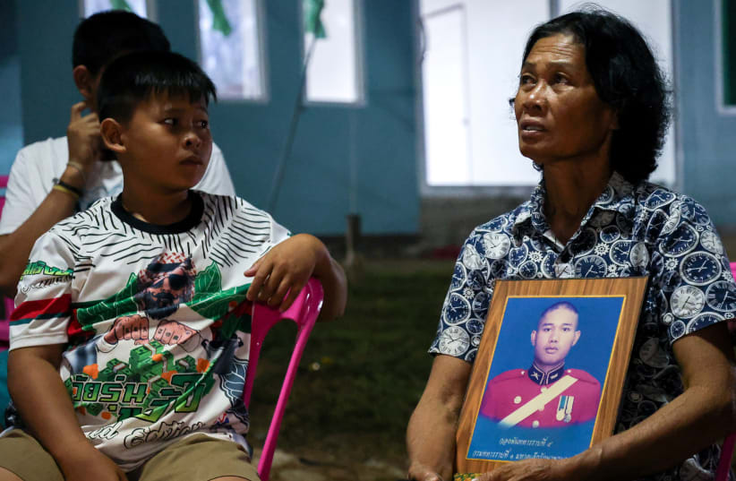  Noopar Pansa-ard, 63, holds up a picture of her son, Somkuan Pansa-ard, 39, a Thai labour who was killed in Israel in the ongoing conflict between Israel and the Palestinian Islamist group Hamas, at his house in Kalasin province, Thailand, October 10, 2023. (photo credit: REUTERS/Thomas Suen)