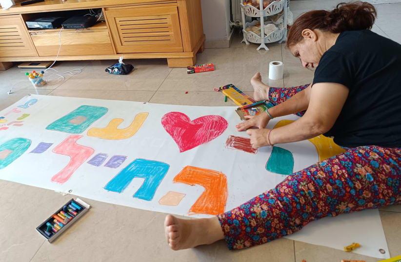 A resident of Shekel during "meaning-making" activities in an apartment for adults with cognitive disabilities. (photo credit: SHEKEL)