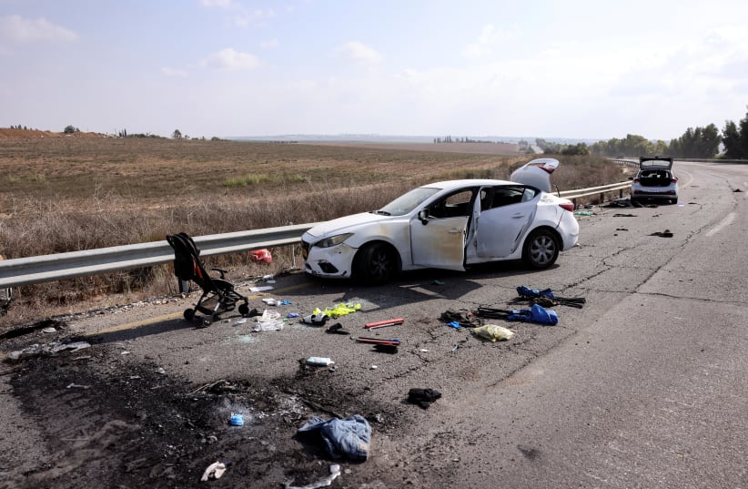 Personal belongings including a child's pram are seen on the road next to a car days after a mass infiltration by Hamas terrorists from the Gaza Strip, near Kibbutz Kfar Aza, in southern Israel, October 10, 2023 (photo credit: RONEN ZVULUN/REUTERS)