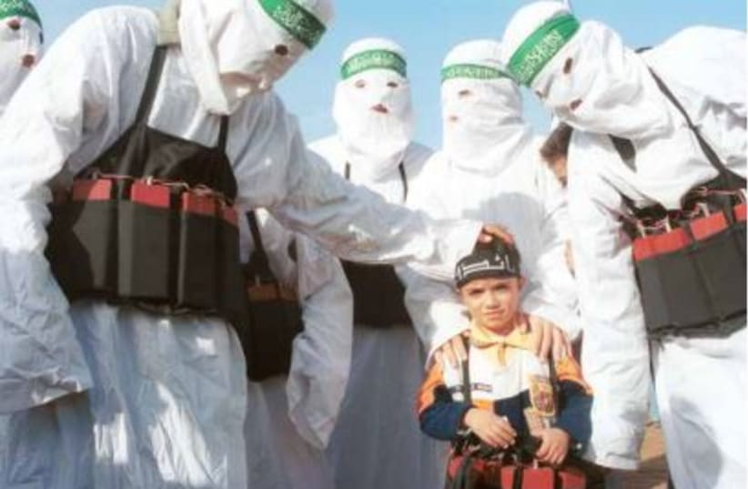  DRESSED AS suicide bombers, Hamas operatives train a small child in their murderous ways.  (photo credit: Courtney Kealy/Getty Images)