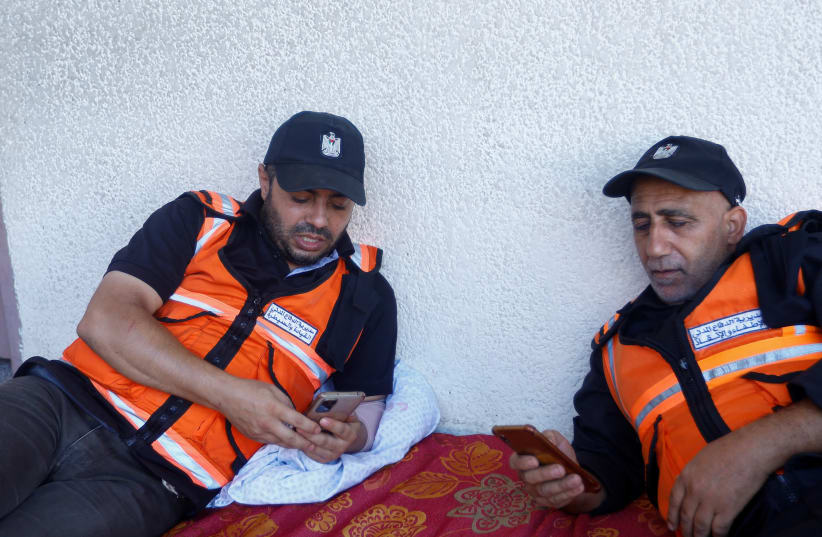  Palestinian rescue worker Ibrahim Hamdan and his colleague wait for an emergency call, amid fear and exhaustion under Israeli air strikes, in Khan Younis in the southern Gaza Strip October 12, 2023. (photo credit: REUTERS/IBRAHEEM ABU MUSTAFA)