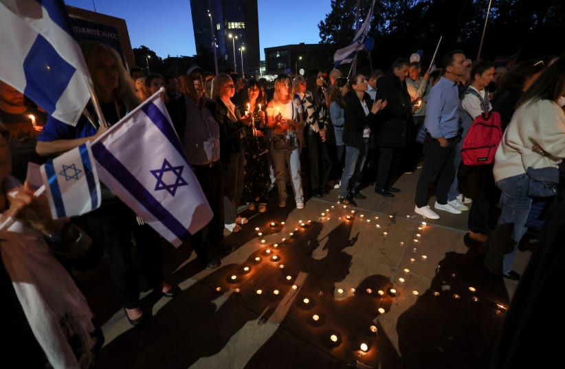  People hold candles during a demonstration organised by the Switzerland-Israel Association against the attacks by Hamas, outside the United Nations in Geneva, Switzerland, October 11, 2023.  (photo credit: REUTERS/DENIS BALIBOUSE)