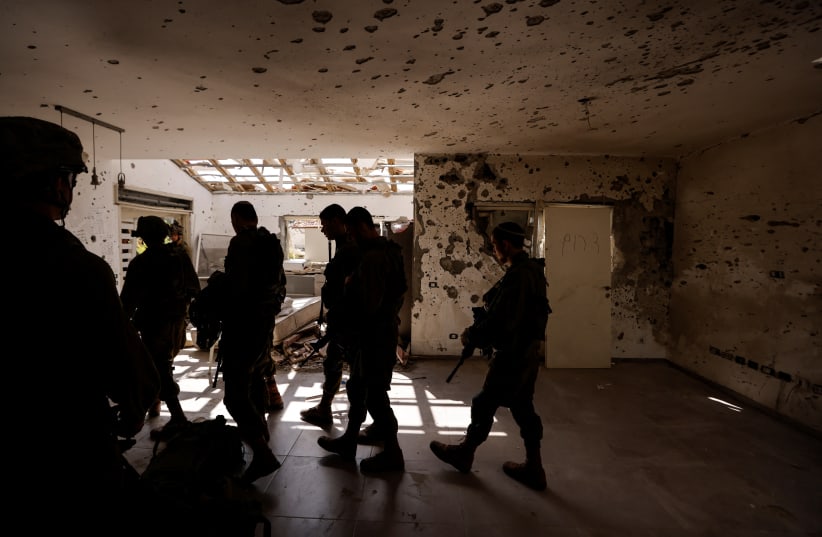  Israeli soldiers patrol the remains of Kibbutz Beeri, following a mass infiltration by Hamas gunmen from the Gaza Strip, in southern Israel, October 13, 2023. (photo credit: REUTERS/AMIR COHEN)