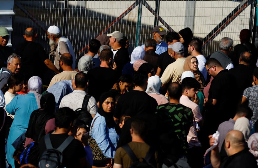 Palestinians with dual citizenship gather outside Rafah border crossing with Egypt in the hope of getting permission to leave Gaza, amid the ongoing Israeli-Palestinian conflict, in Rafah in the southern Gaza Strip October 16, 2023 (photo credit: REUTERS/IBRAHEEM ABU MUSTAFA)