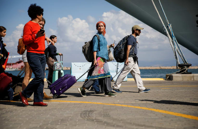  People carry their personal belongings before boarding a ship for U.S. nationals and their immediate family members, as they leave Israel headed for Cyprus, amid the ongoing conflict between Israel and the Palestinian Islamist group Hamas, in Haifa, Israel, October 16, 2023. (photo credit: REUTERS/SHIR TOREM)