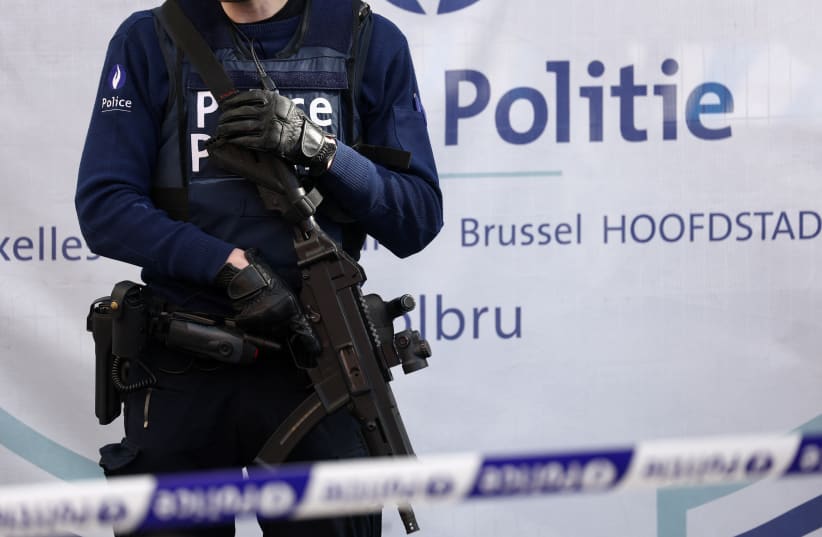  A police officer stands guard outside the site of a police operation against a deadly shooting suspect, in Schaerbeek, Brussels, Belgium, October 17, 2023. (photo credit: REUTERS/YVES HERMAN)