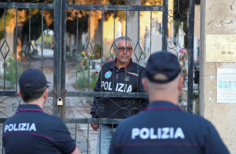  Police stand outside the cemetery, where late mafia boss Matteo Messina Denaro is buried, in the Sicilian town of Castelvetrano, Italy, September 27, 2023. (photo credit: REUTERS/Igor Petyx)