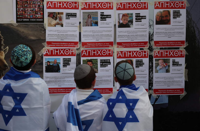  Young boys look at posters depicting missing people and stating that they were kidnapped by Hamas militants outside a Synagogue in Larnaca, Cyprus October 17, 2023. (photo credit: REUTERS/YIANNIS KOURTOGLOU)
