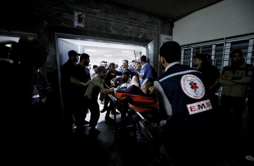  An injured person is assisted at Shifa Hospital after hundreds of Palestinians were killed in a blast at Al-Ahli hospital in Gaza  City, Gaza Strip, October 17, 2023 (photo credit: REUTERS/MOHAMMED AL-MASRI)