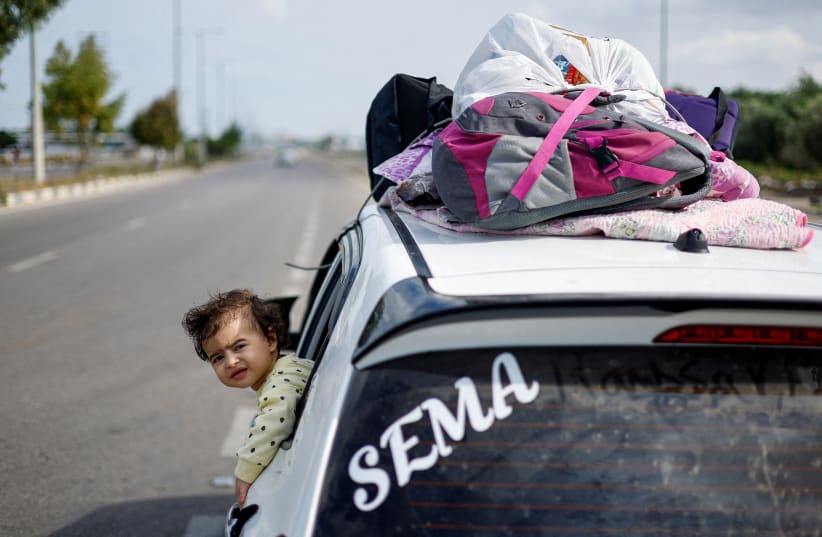  The daughter of Palestinian woman Raghda Abu Marasa, who fled to the southern part of the enclave after Israel's call for more than 1 million civilians in northern Gaza to move south, rides in a car with her family members as they return to their home in Gaza City, citing a lack of refuge elsewhere (photo credit: REUTERS/MOHAMMED SALEM)