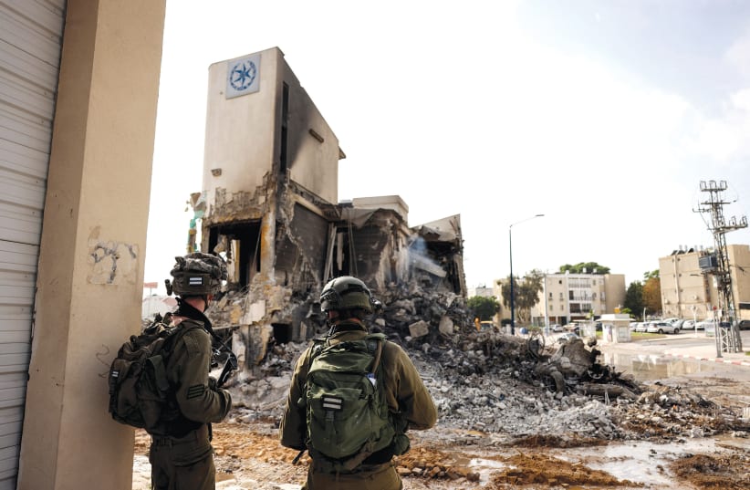  IDF soldiers inspect the remains of a police station in Sderot, which was the site of a battle following a mass infiltration by Hamas gunmen from the Gaza Strip, on October 8.  (photo credit: RONEN ZVULUN/REUTERS)